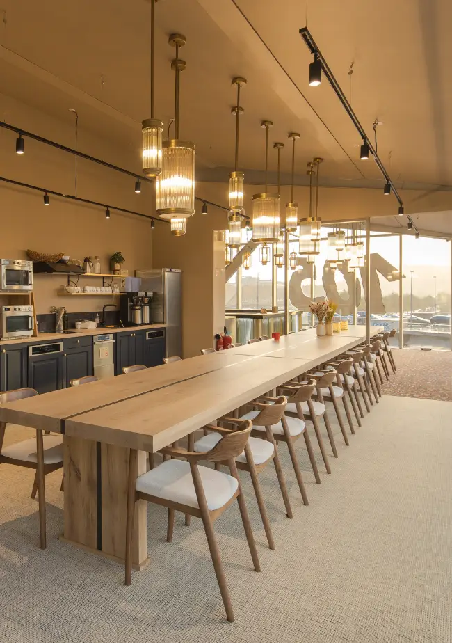 Cuisine partagée avec longue table et luminaires design chez Now coworking Rouen.