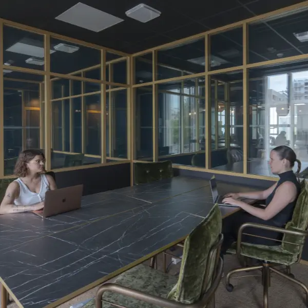 Coworker installé dans un bureau design avec une grande table en marbre.