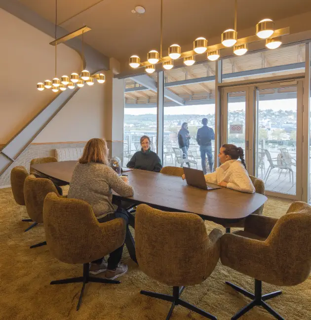 Coworkers en réunion dans une salle lumineuse avec vue sur la Seine.