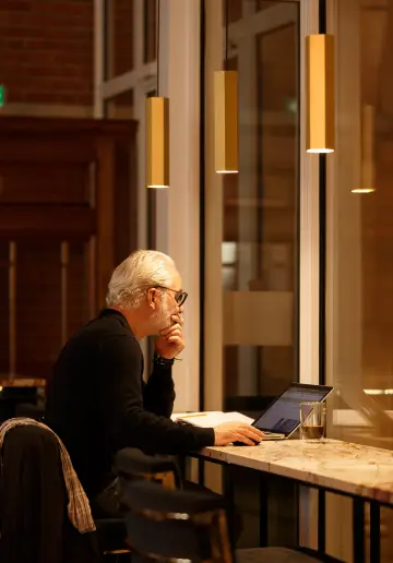 Deux coworkers discutant autour d’une table en verre dans un espace moderne à Now Lille.