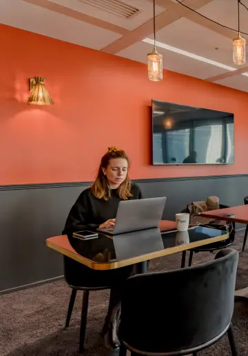 Coworker travaillant dans une salle moderne et lumineuse chez Now coworking La Défense