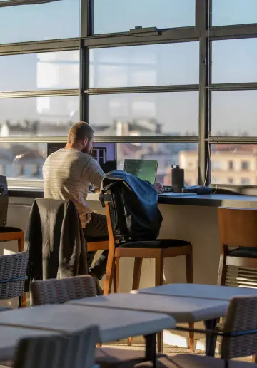 Espace moderne chez Now coworking Lyon avec coworkers en discussion autour d'une table.