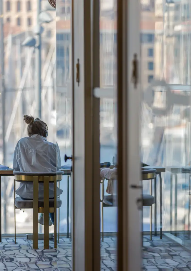 Coworker concentré dans une salle privée avec vue sur le port à Now Marseille.