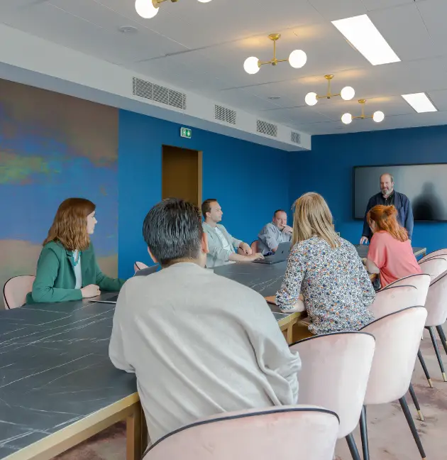 Groupe en discussion autour d’une grande table à Now Courbevoie SmartParc.