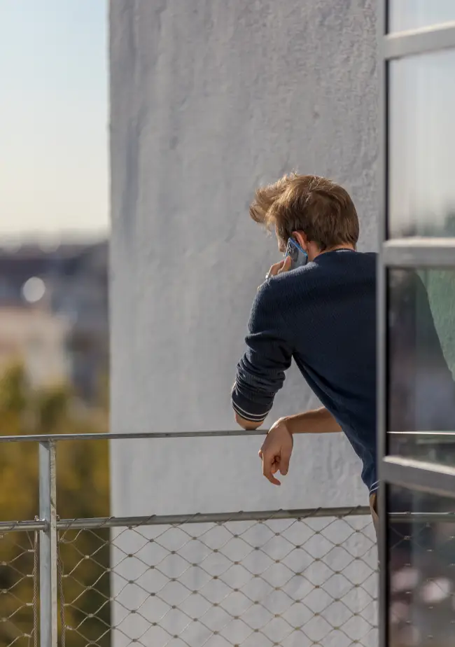 Coworker profitant d'un appel sur le rooftop de Now coworking Lyon avec vue sur la ville.